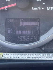 Dashboard gauge cluster showing fuel and DEF indicators, digital odometer displaying 136,624 miles, bars for DEF and fuel levels, and warning text at bottom.