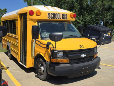 Yellow school bus body with 152 on hood and SCHOOL BUS sign on top front, side door open, Chevrolet emblem on grille, black bumper.