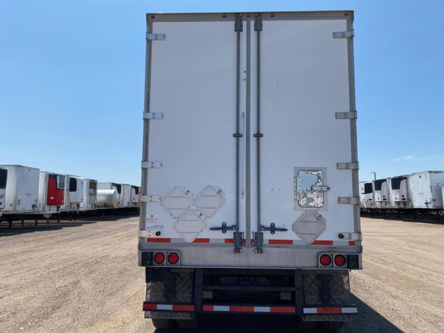 Truck trailer rear doors and bumper with reflective tape and taillights in a lots of trailers.