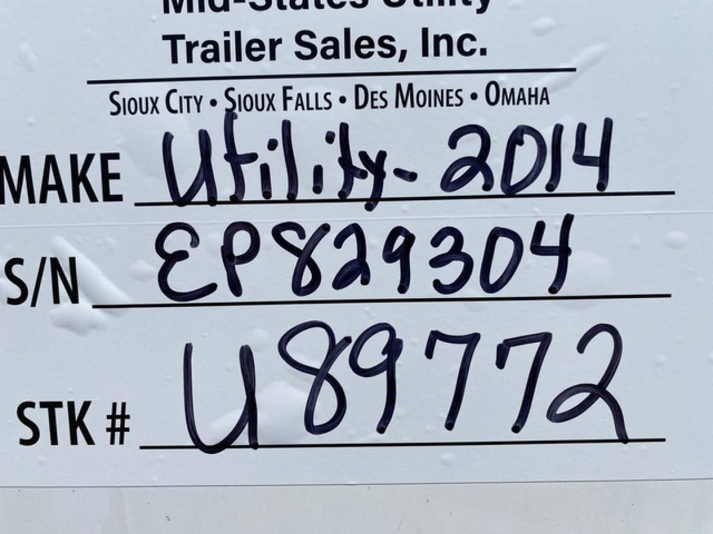 Tag on trailer showing Make: Utility 2014, S/N: EP829304, STK #: U89772, VIN: 1UYVS2531EP829304, S/N line handwritten.