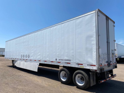 Trailer side view showing a long rectangular box trailer with dual rear wheels and Air Ride Equipped badge on lower side.