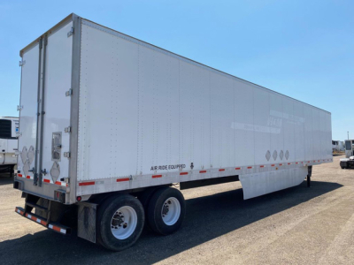 Utility van trailer showing double rear doors and Tandem axles with white exterior and reflective tape along lower edge.