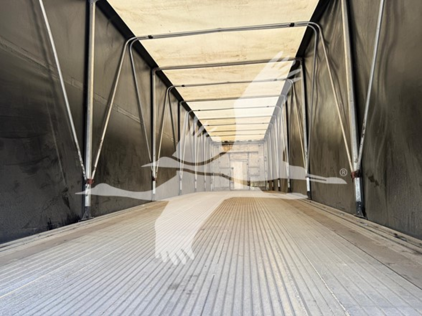 Trailer interior showing aluminum floor and curtain sides in a Mac aluminum flatbed trailer.