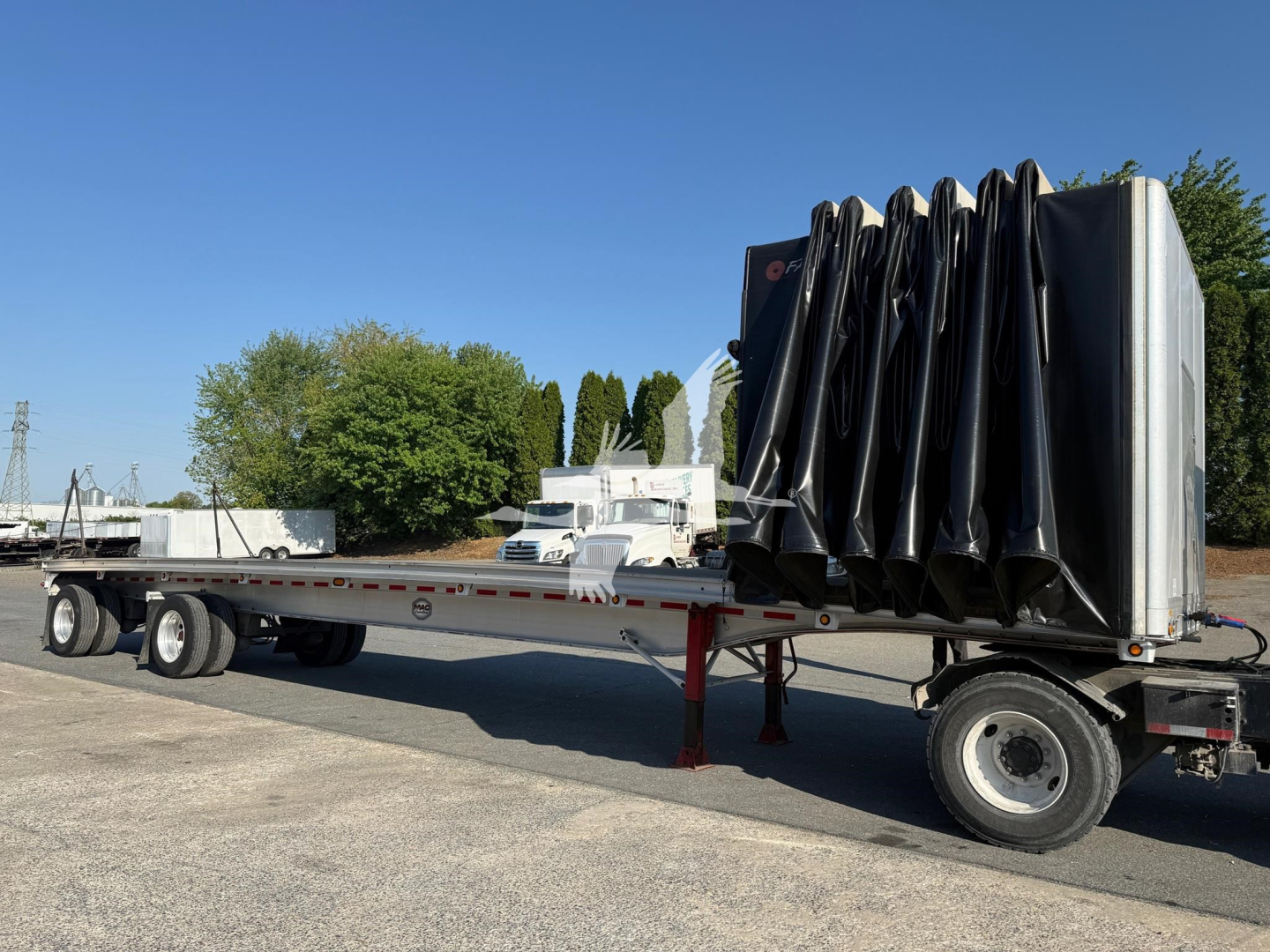Trailer shown in side view with folded curtain side, long flatbed section, dual rear axles, and raised tarp system on the right side.