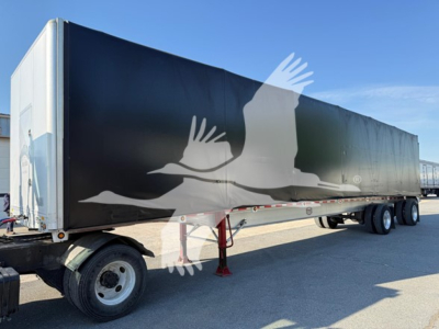 Trailer side showing large graphic of a flying bird or eagle on black background; front wheel and support legs visible; no detailed text legible.