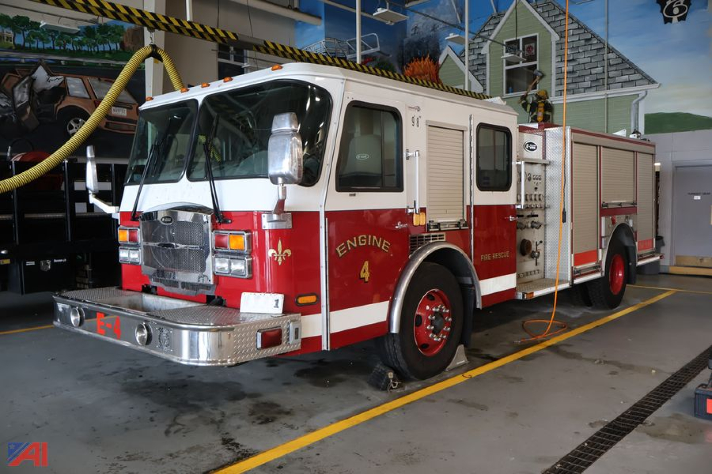 Fire engine cab-over-engine truck in service bay showing Engine 4 markings and red-and-white livery.