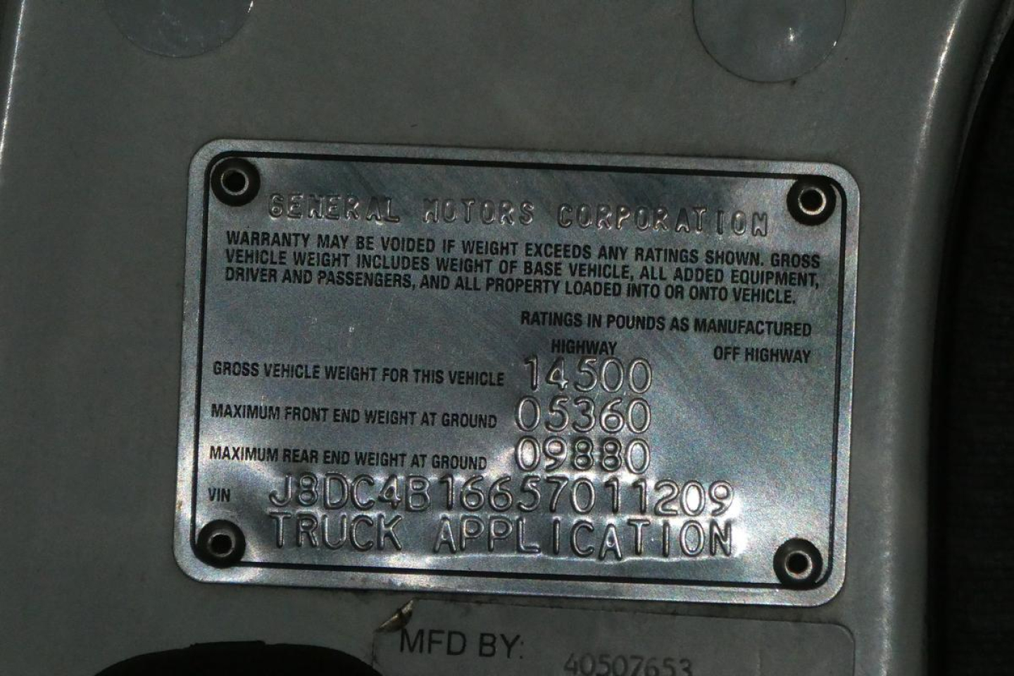 General Motors Corporation metal plate showing gross vehicle weight and VIN details on GMC W4500 truck; includes weights and Vehicle Identification Number.