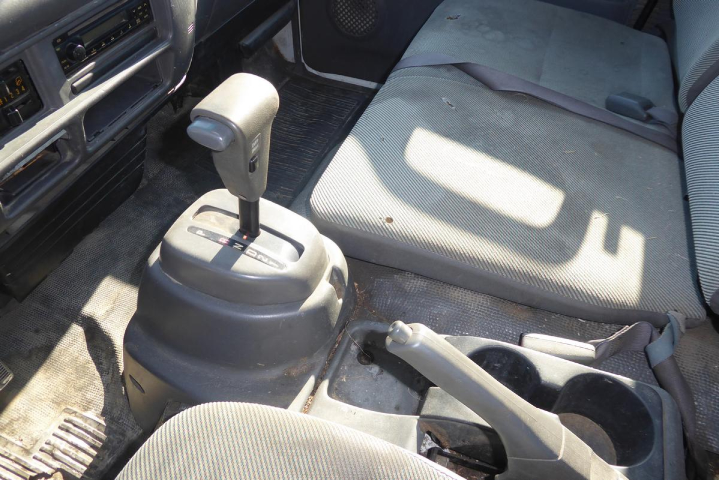 GMC W4500 interior featuring manual shift lever and center console with seating and dashboard visible.