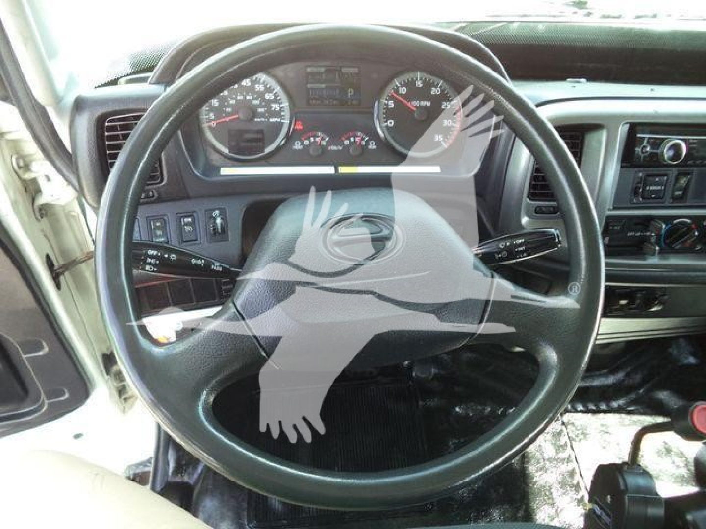 Dashboard and steering wheel view of a 2016 Hino 268A dump truck interior. Visible gauges, steering wheel, and center console.
