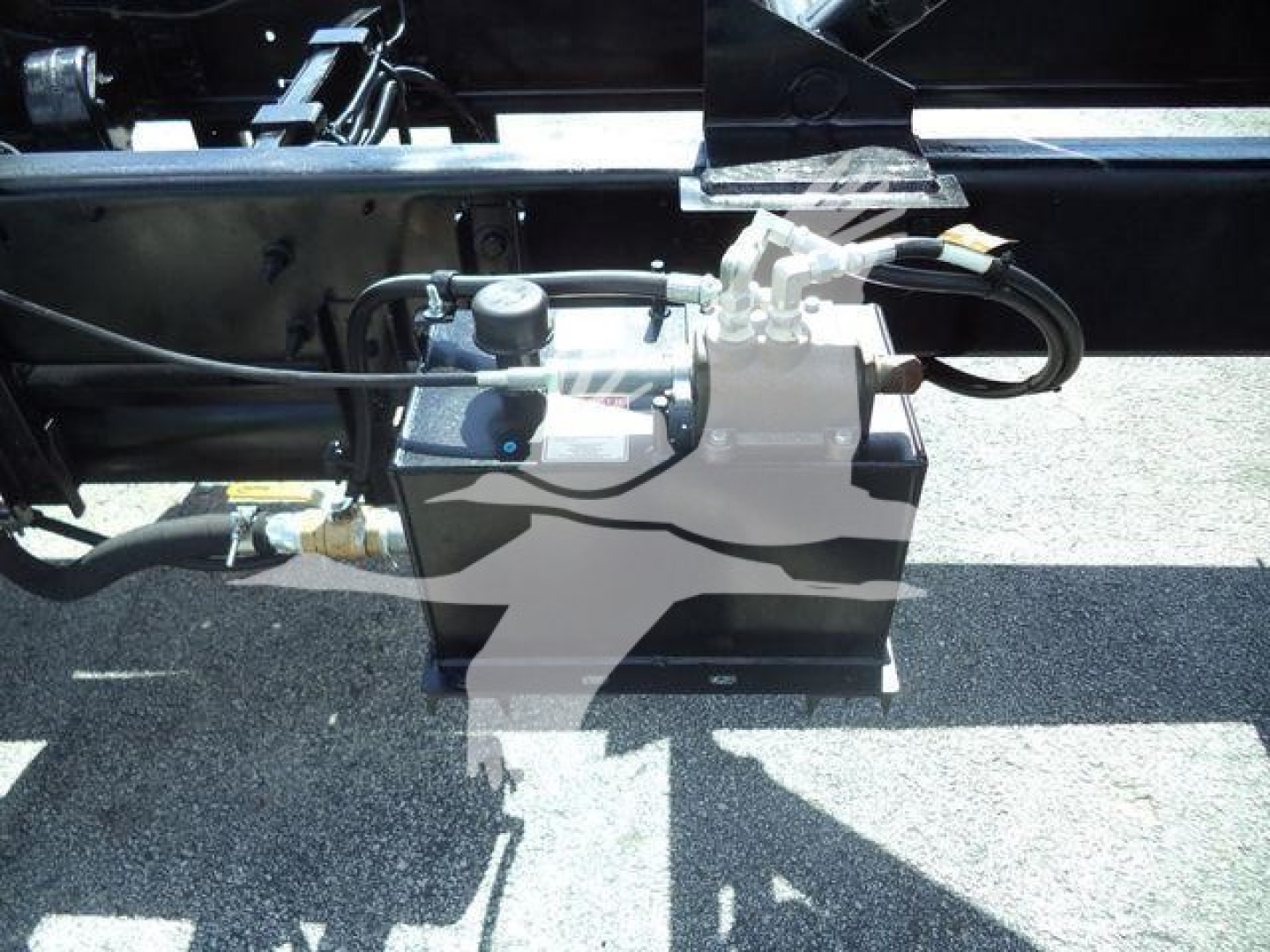 Hino 268A undercarriage showing hydraulic pump and lines with control valve mounted on frame.