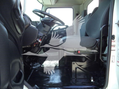 Cab interior of a 2016 Hino 268A dump truck, driver seat on left, steering wheel, dashboard, and entry steps visible.
