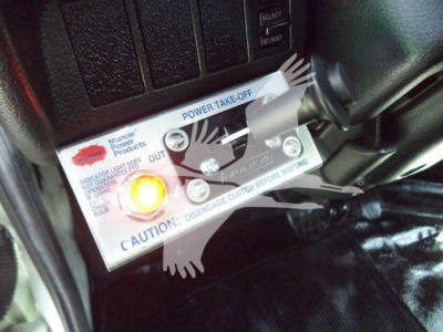 Close-up of a panel showing a Power Take-Off (PTO) lever with labels: 'Power Take-Off', 'Disengage Clutch Before Shifting', 'Caution', with a circular orange indicator light.
