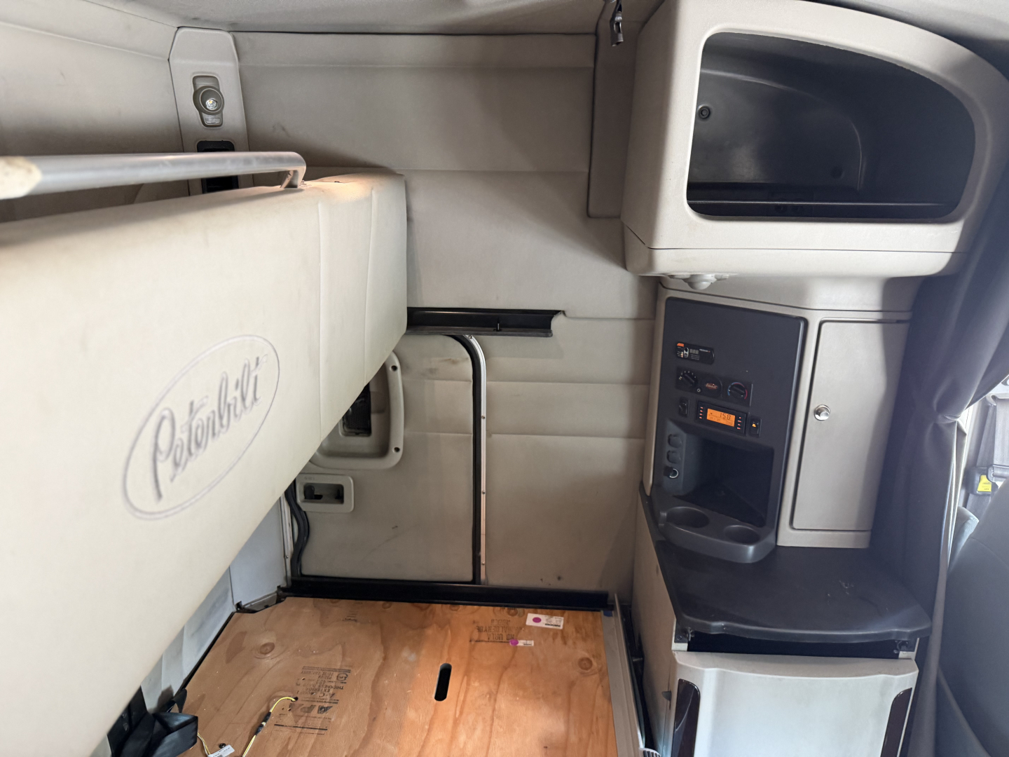 Peterbilt 579 cab interior showing sleeper area with storage cabinet and control panel