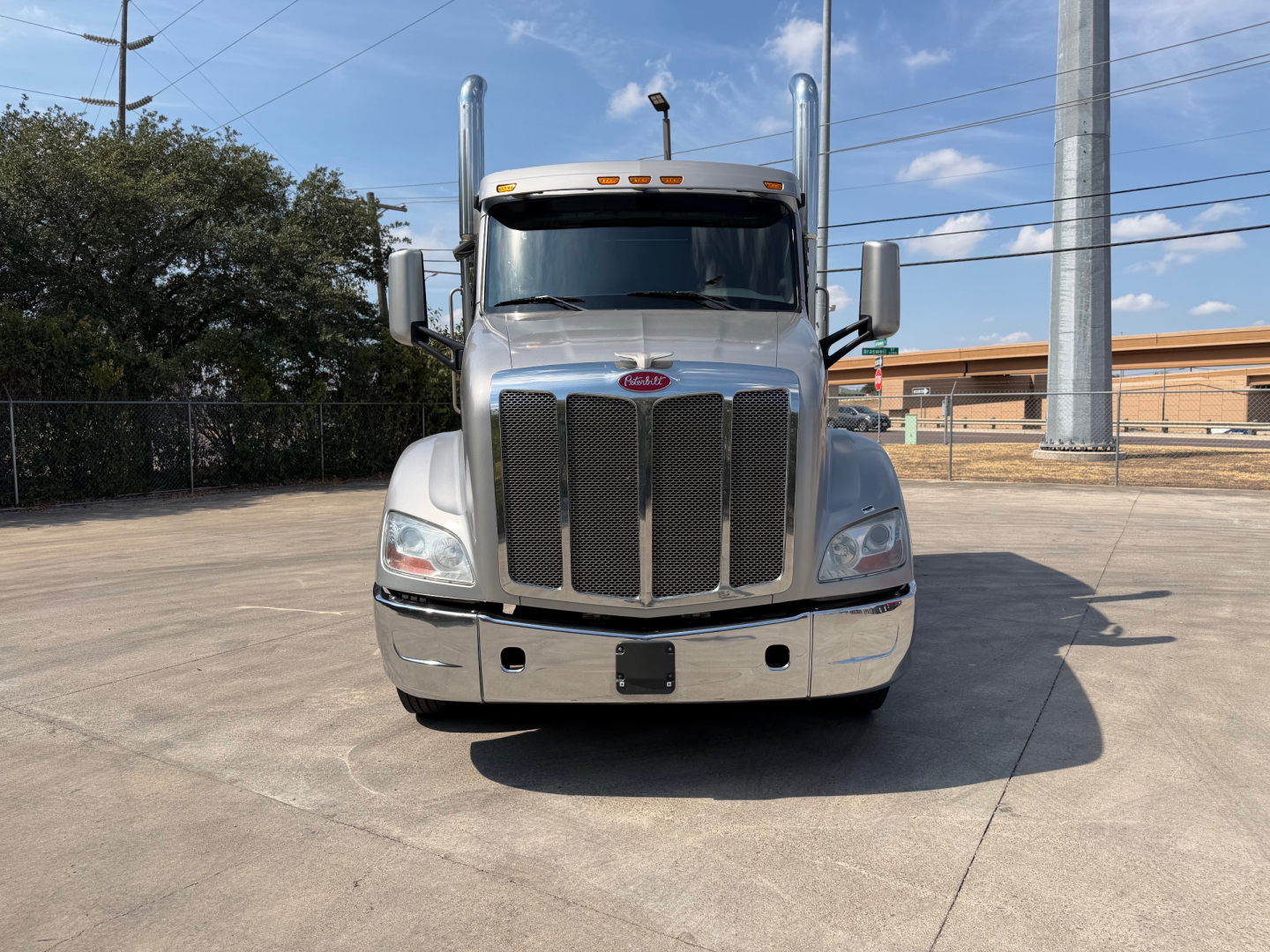 Peterbilt 579 front view showing large grille, chrome bumper, dual exhaust stacks, and side mirrors.