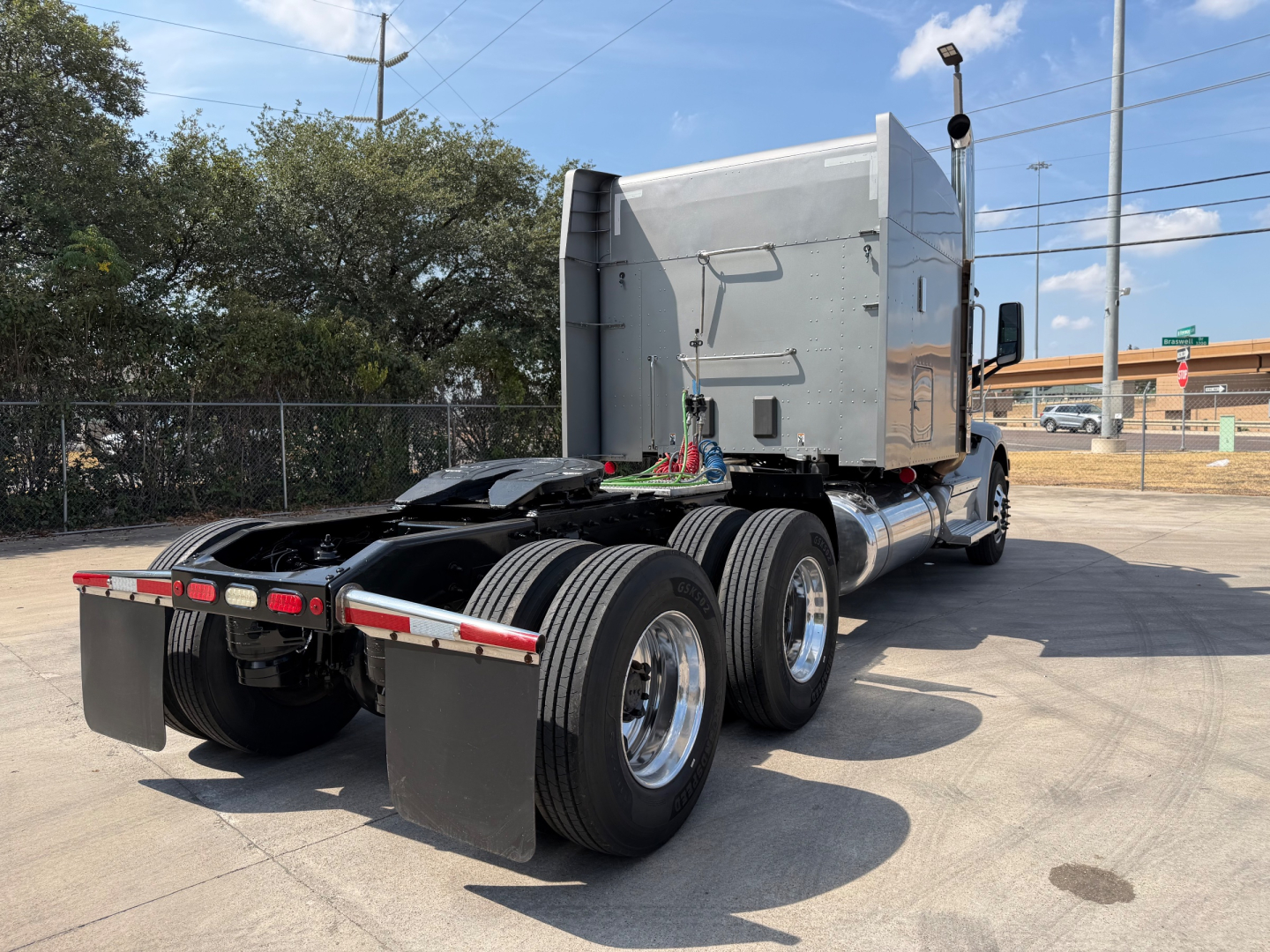Peterbilt 579 tractor rear chassis with dual rear axles and fifth wheel, aluminum sleeper cab, metal fuel tanks, and mud flaps.