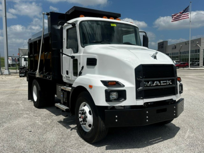 Mack MD7 dump truck in white, front three-quarter view with black grille and load bed visible.