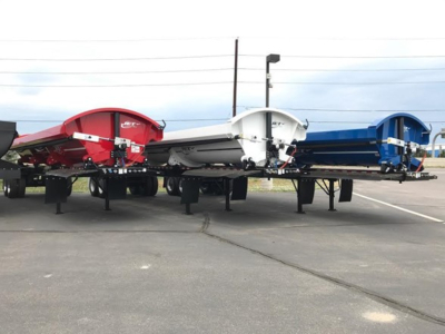 Jet SIDE DUMP trailers in red, white, and blue colors with multiple pivot points on each side.