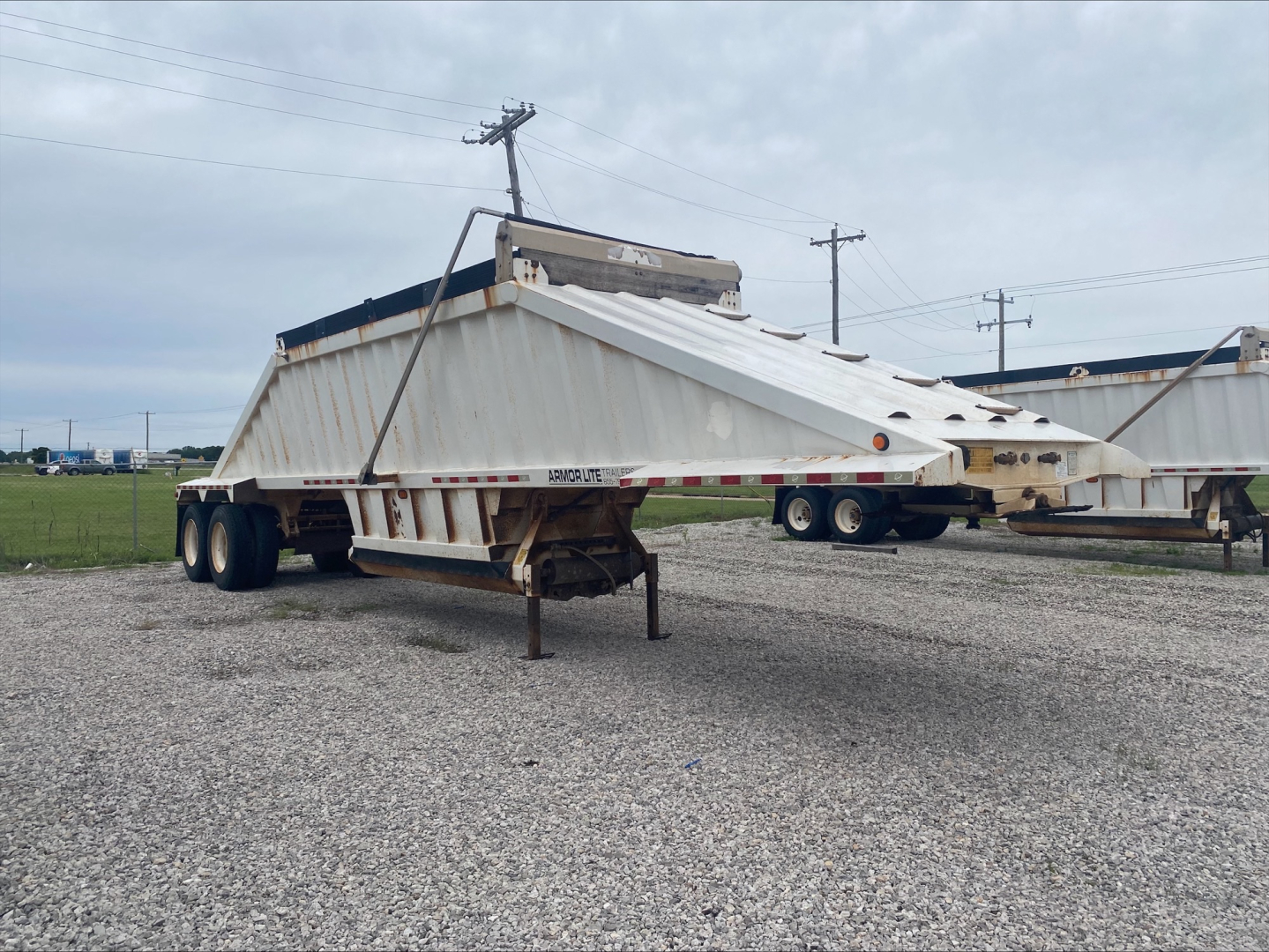 Dump trailer in-service showing Armor Lite SBD40 skeleton dump trailer with dual rear axles and hydraulic system on top.