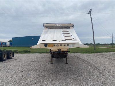 Dump trailer rear view showing Armor Lite SBD40 skeleton dump bed with hydraulic mechanism and support legs.