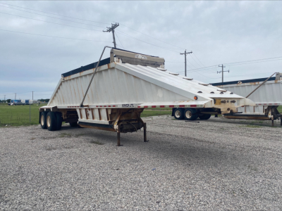Dump trailer in-service showing Armor Lite SBD40 skeleton dump trailer with dual rear axles and hydraulic system on top.