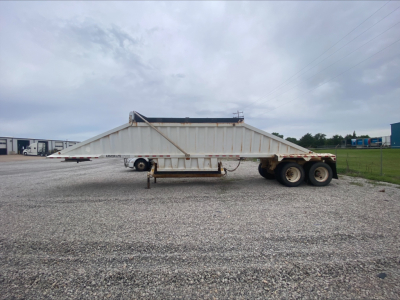 Dump trailer sideways view showing Armor Lite SBD40 spring skeleton with dual rear axles and elevated side walls.