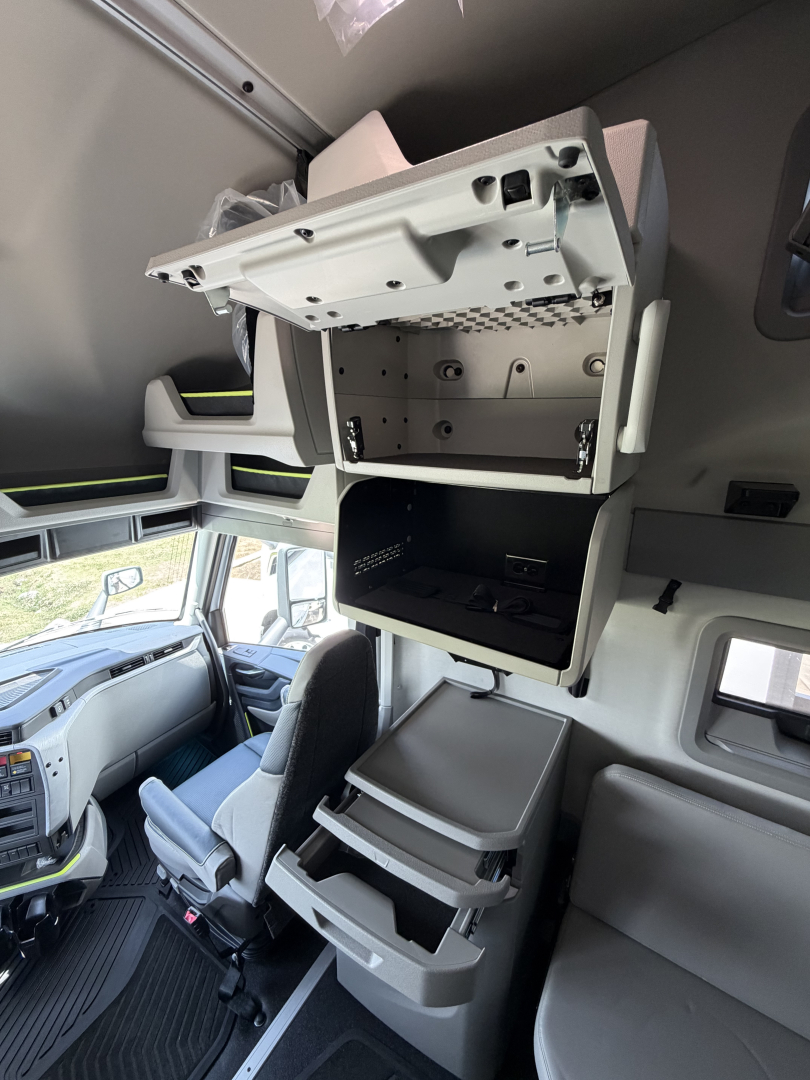 Cab interior showing overhead storage compartments and driver seat in Volvo VNL truck cabin.