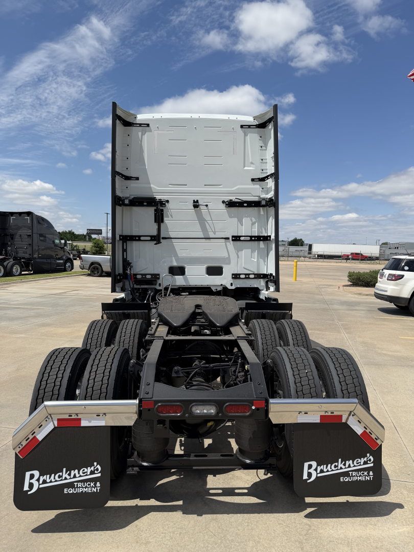 Truck rear view showing fifth wheel area and dual rear axle configuration with mud flaps and bumper; Volvo VNL64T860 cab-back view from behind.
