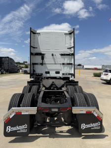 Truck rear view showing fifth wheel area and dual rear axle configuration with mud flaps and bumper; Volvo VNL64T860 cab-back view from behind.