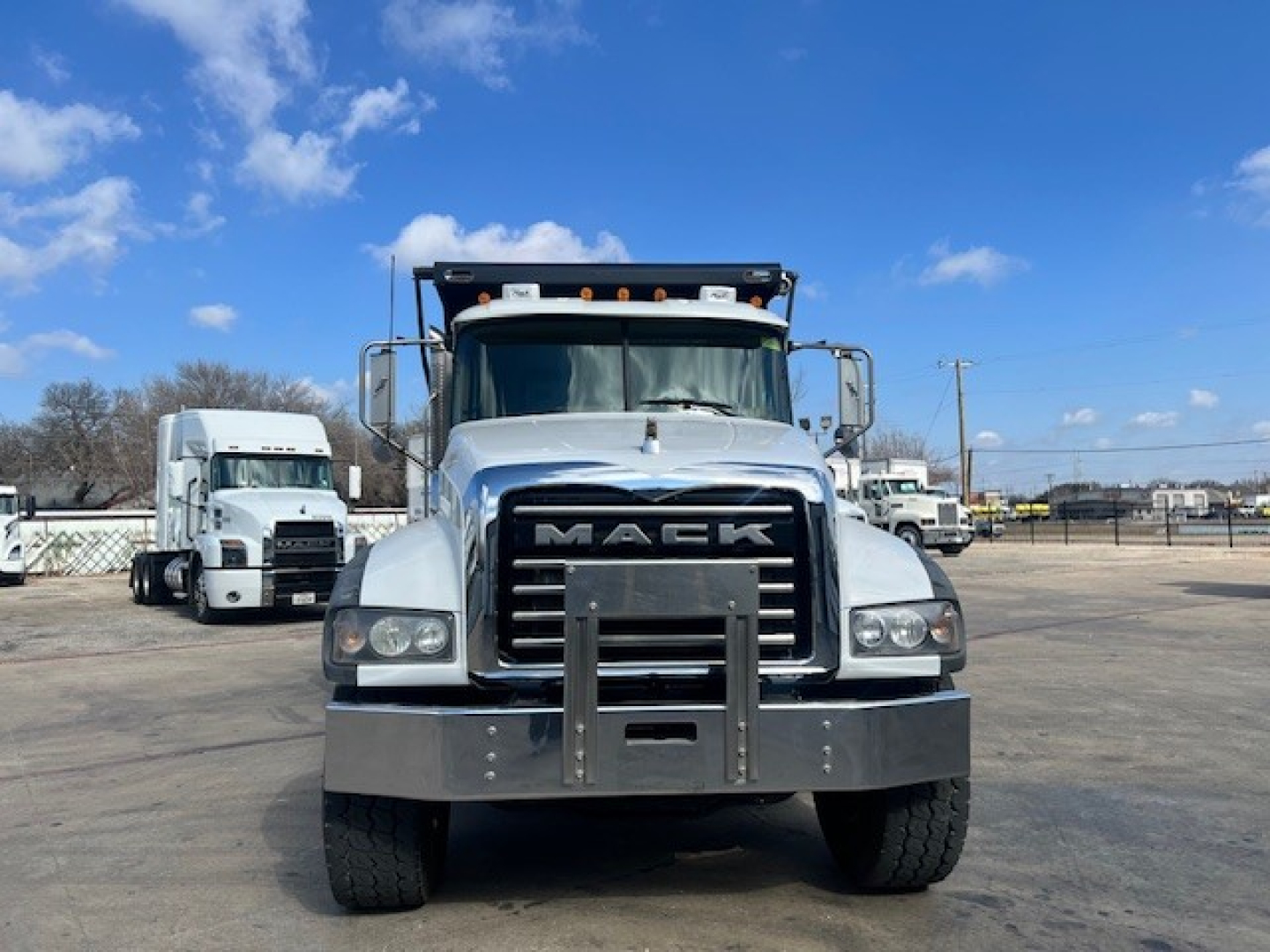Mack GU713 dump truck front view showing large grille and bumper guard with headlamps