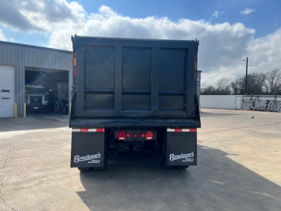 Dump truck bed of a 2018 Mack GU713 viewed from rear, showing the open-top cargo bed and rear bumper with taillights. Stock and VIN not visible.