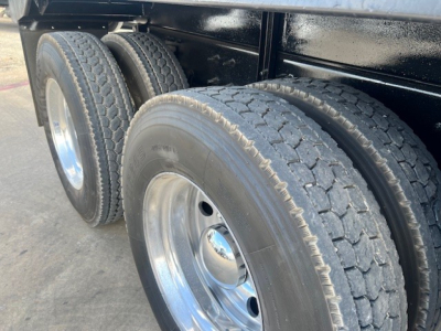 Truck rear dual wheels with heavy-duty tires and polished chrome rims on a Mack GU713 dump truck chassis.