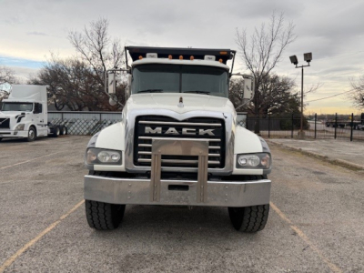 Mack GU713 front view truck showing large black grille with 'MACK' lettering; bumper and license plate area; headlights on both sides; white cab; highway-style mirrors.