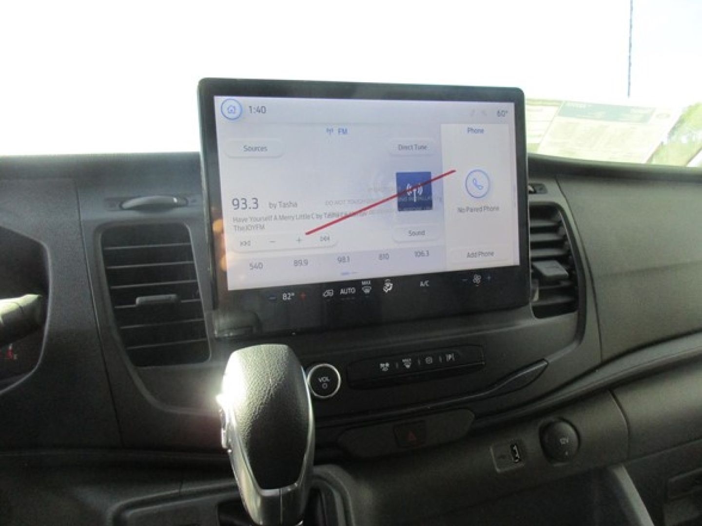 Ford Transit cabin showing touchscreen infotainment system, gear shifter, and dashboard controls.