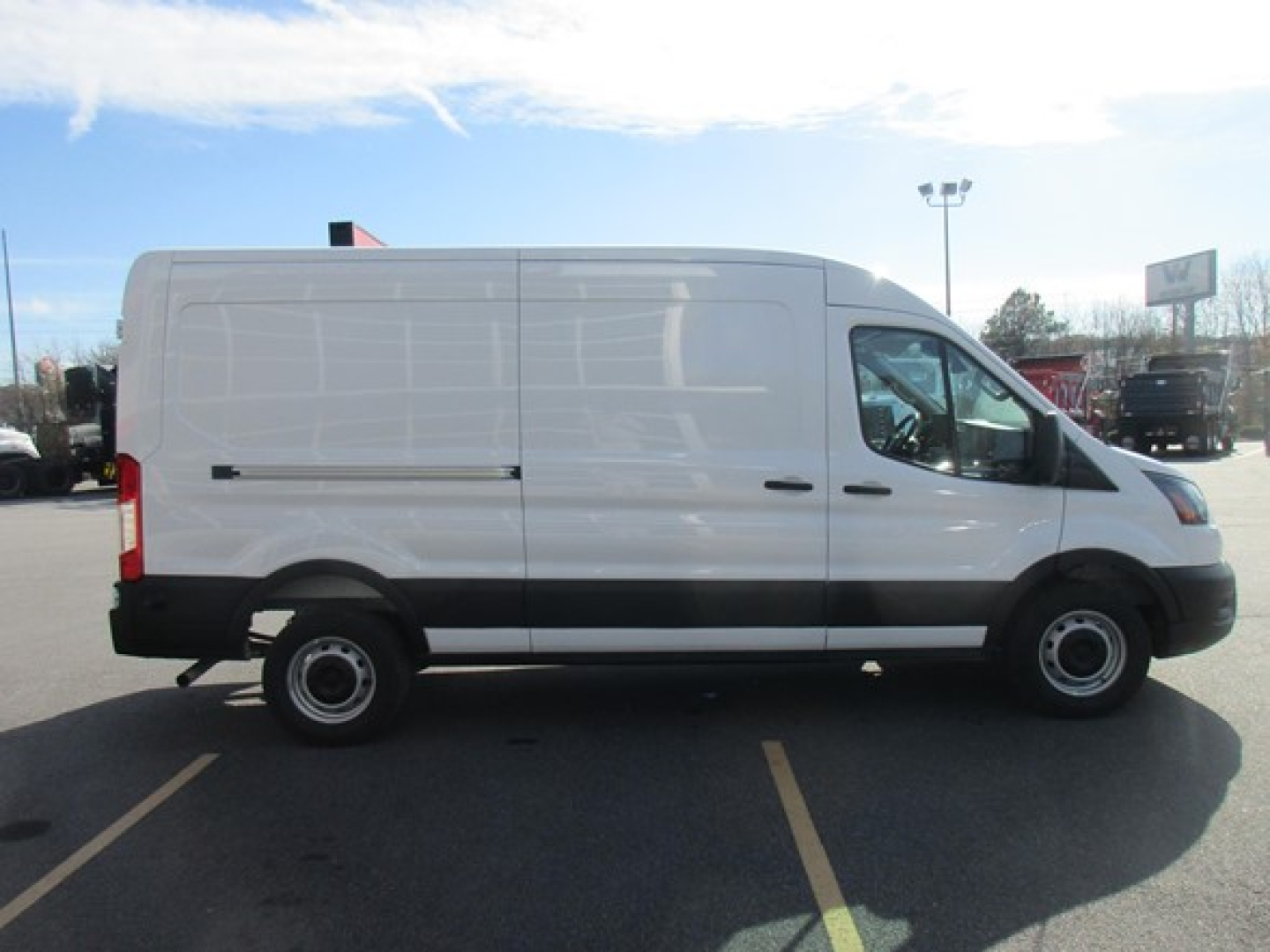 Ford Transit cargo van side view showing blank white panel, black trim, and wheel wells.