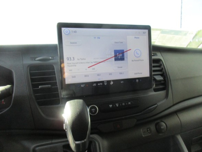 Ford Transit cabin showing touchscreen infotainment system, gear shifter, and dashboard controls.
