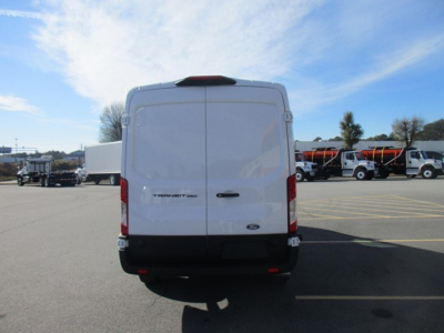 Ford Transit cargo van rear view in a dealership lot with other trucks in background