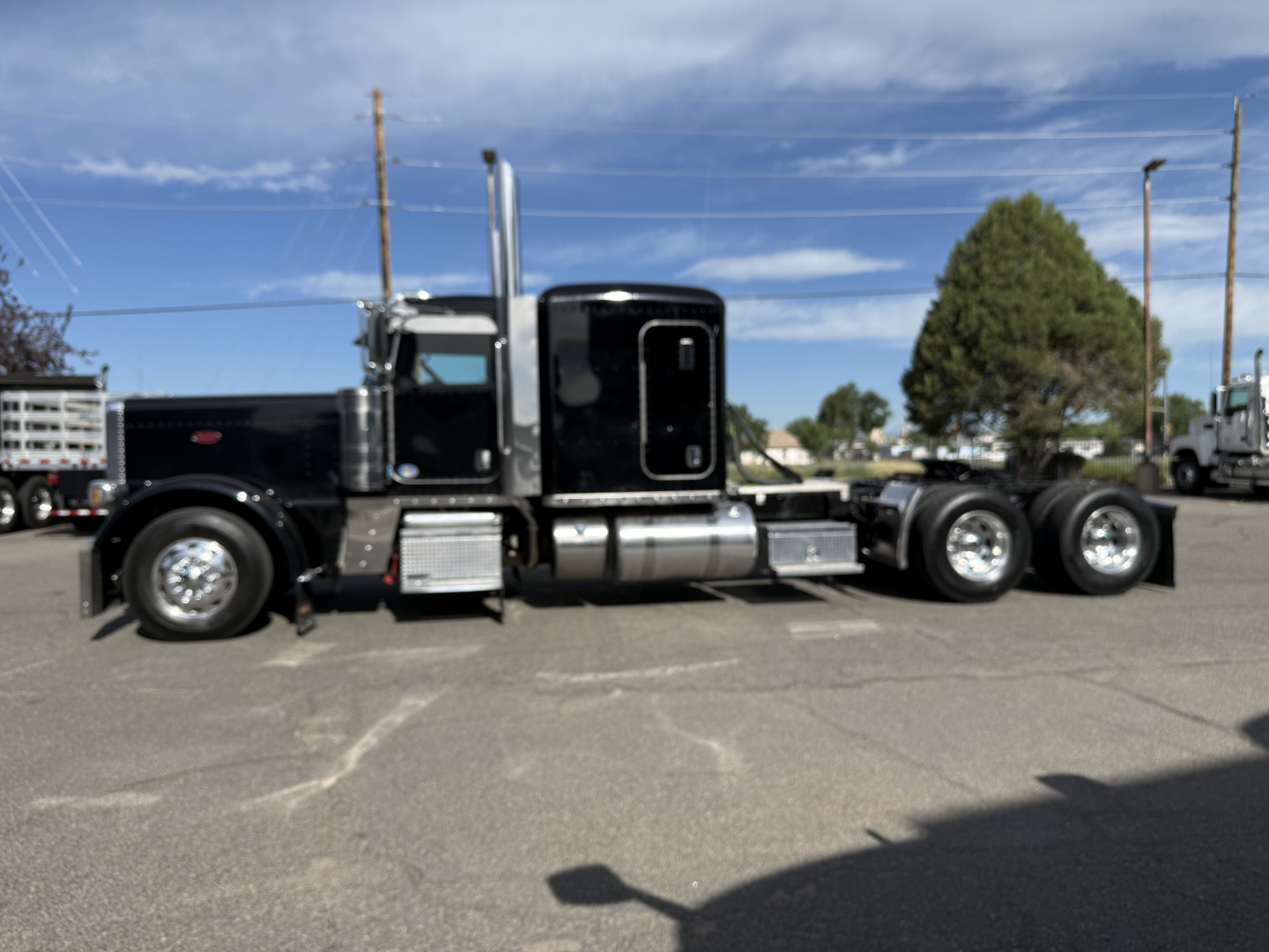 Peterbilt 389 conventional sleeper truck in side view showing cab, exhaust stacks, fuel tanks, and dual rear axles.