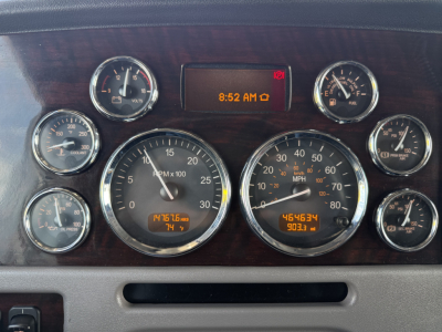 Peterbilt 389 dashboard cluster with multiple gauges, digital display shows 8:52 AM, tachometer 0- and road speedometer, trip meters and fuel gauges visible.