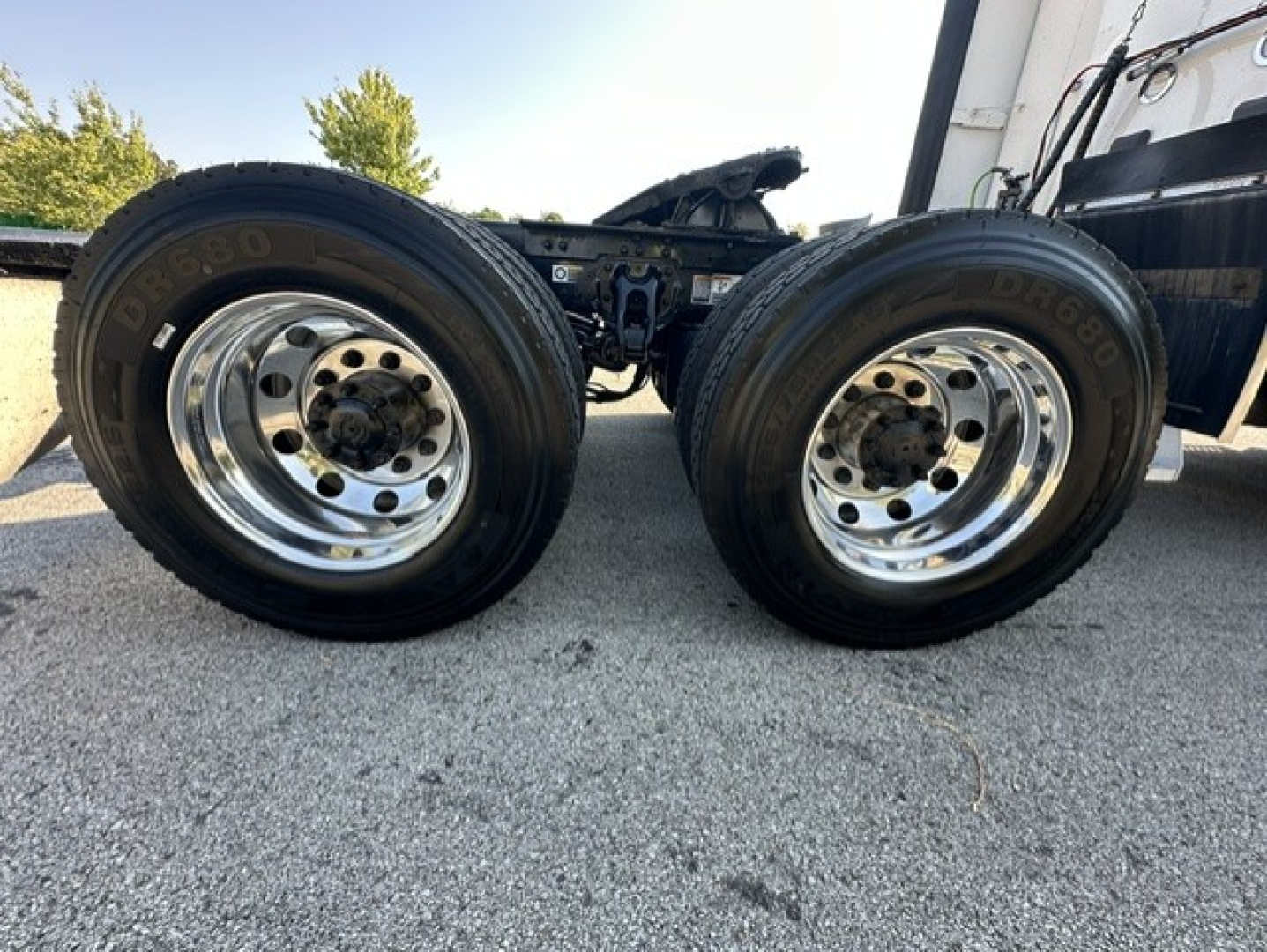 Kenworth T680 chassis showing dual rear wheels and chrome rims, with tires labeled BRIDGEMARK and road surface.