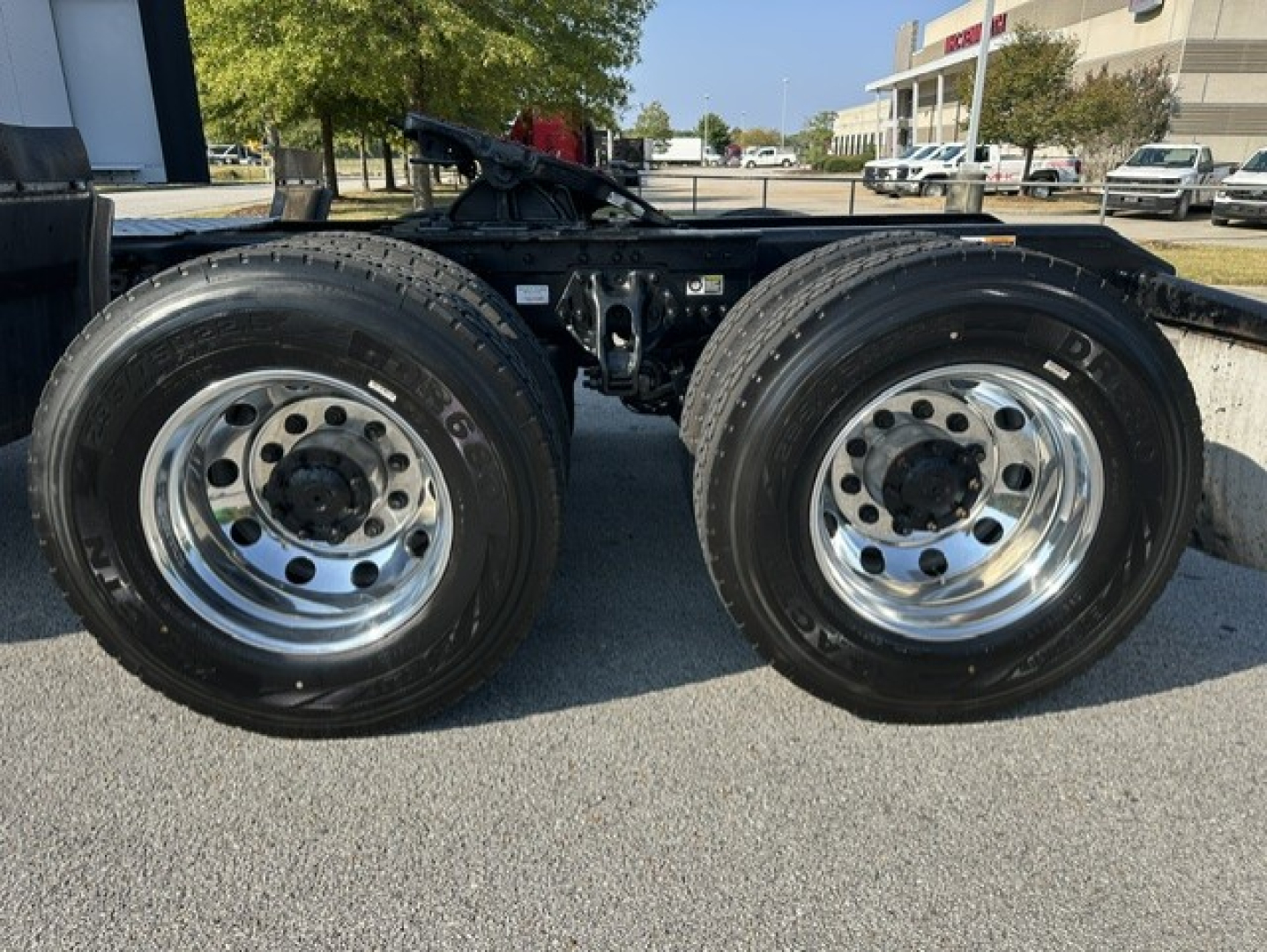 Kenworth T680 chassis with dual rear wheels showing shiny chrome rims and black frame.