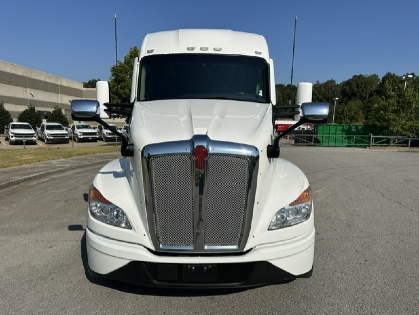 Front view of a white 2023 Kenworth T680 truck showing large chrome grille, headlights, and Kenworth emblem.