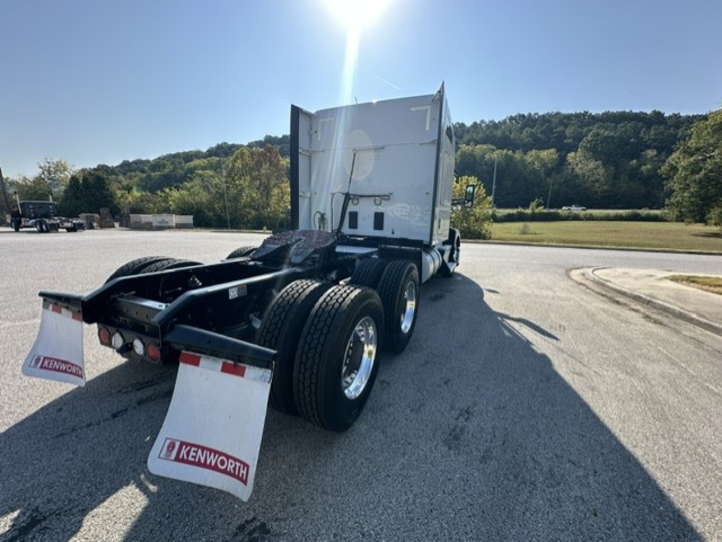 Kenworth T680 rear view showing mud flaps with Kenworth logos, rear wheels, and trailer hitch area. No visible model badges or VIN text.