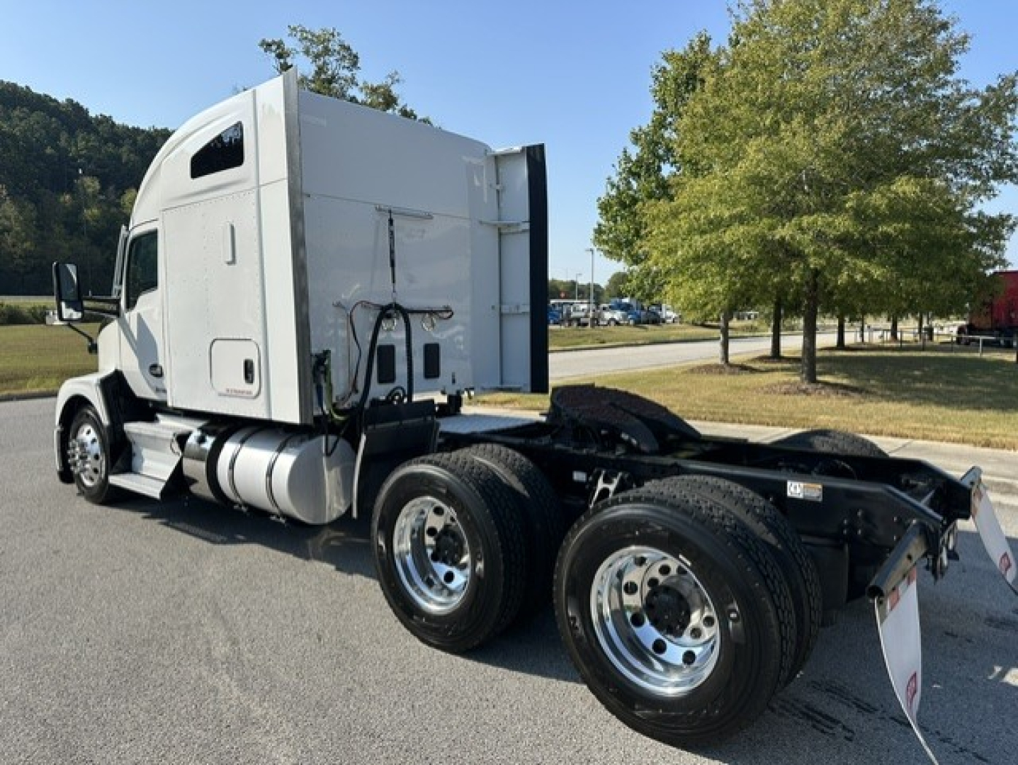 Kenworth T680 tractor cab and chassis showing dual rear axles and fifth wheel, white cab with fuel tanks, no trailer attached.