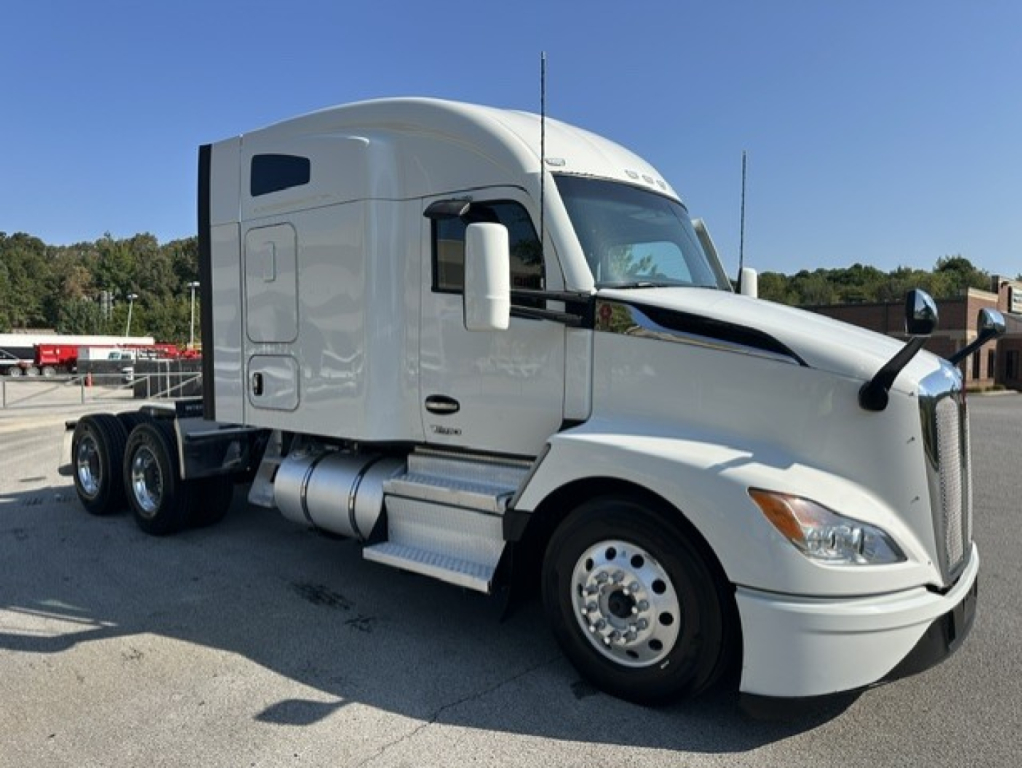 Kenworth T680 tractor unit in service showing side view with sleeper cab, chrome fuel tanks, and dual rear axles