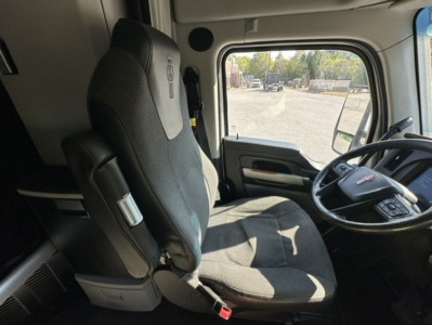 Truck cab interior showing driver's seat and steering wheel of a 2023 Kenworth T680.