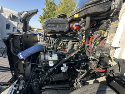 Kenworth T680 engine bay with clean diesel engine and various hoses; visible labels on the radiator support and engine components.