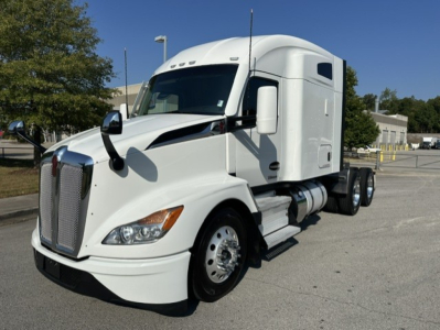 Kenworth T680 conventional sleeper truck left front view showing large grille and white cab with sleeper compartment