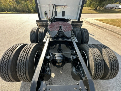 Kenworth T680 rear chassis view showing dual rear axles and fifth wheel plate with visible tires and suspension components.