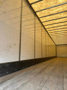 Inside of a 2016 Wabash van trailer with wooden floor and aluminum side walls; empty cargo area.
