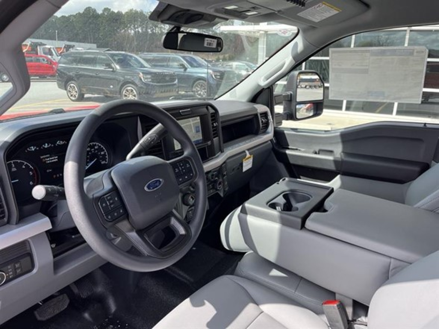 Ford F-350 Super Duty cab and chassis interior view showing steering wheel, dashboard, center console with cupholders, and large touchscreen display.